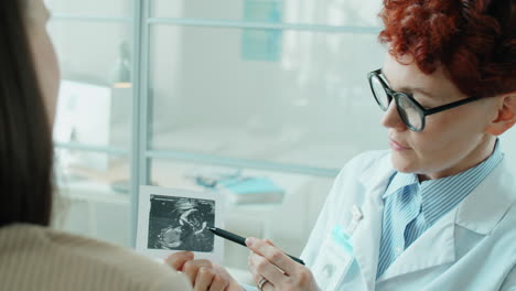 Female-Doctor-Explaining-Ultrasound-Image-of-Baby-to-Woman